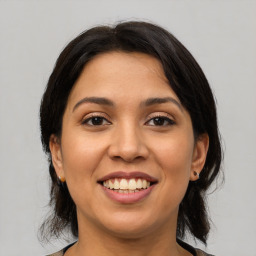 Joyful latino young-adult female with medium  brown hair and brown eyes