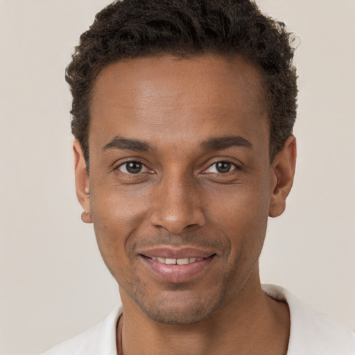 Joyful black young-adult male with short  brown hair and brown eyes