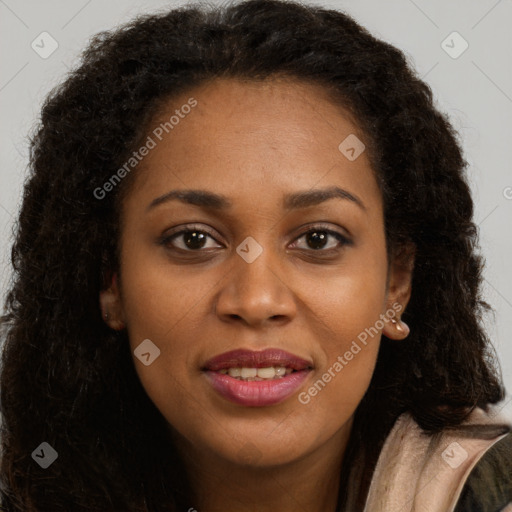 Joyful black young-adult female with long  brown hair and brown eyes