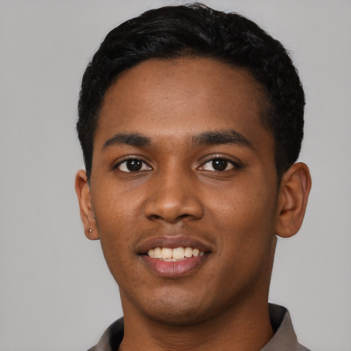 Joyful black young-adult male with short  black hair and brown eyes