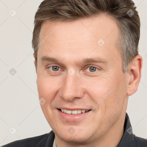 Joyful white adult male with short  brown hair and grey eyes