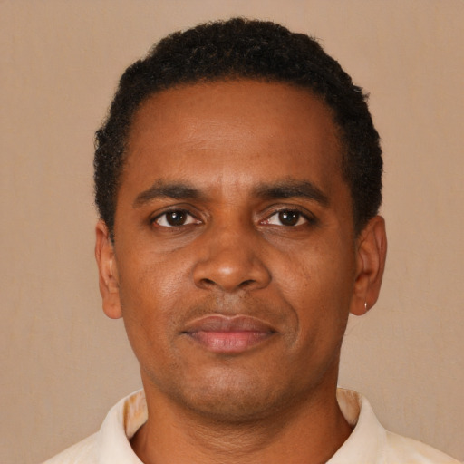 Joyful black young-adult male with short  black hair and brown eyes