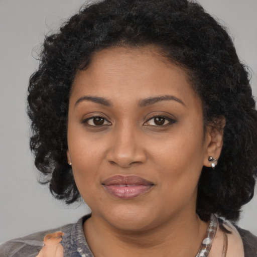 Joyful black young-adult female with medium  brown hair and brown eyes