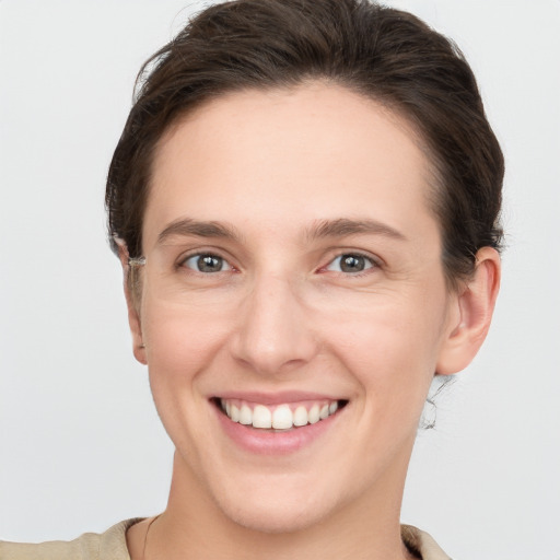 Joyful white young-adult female with short  brown hair and grey eyes