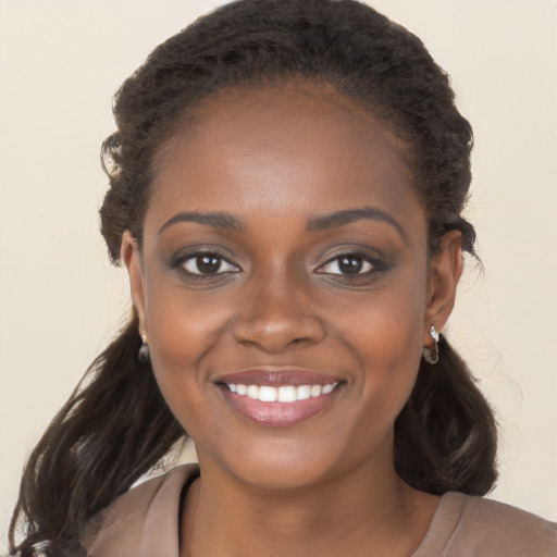 Joyful black young-adult female with long  brown hair and brown eyes