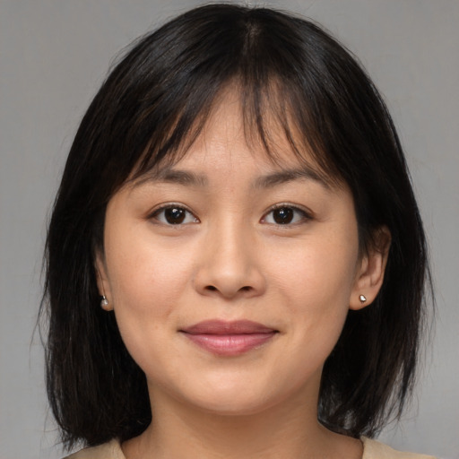 Joyful asian young-adult female with medium  brown hair and brown eyes