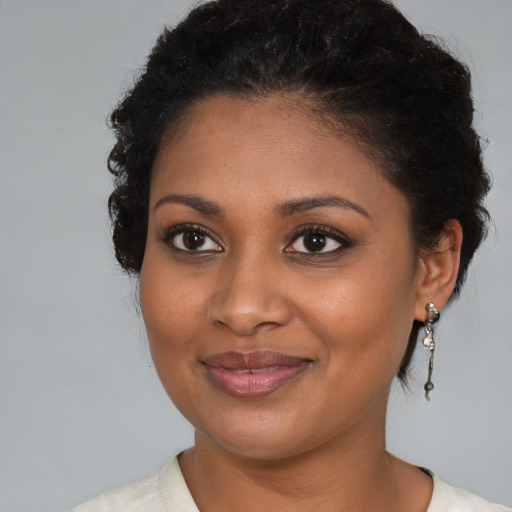 Joyful black young-adult female with medium  brown hair and brown eyes