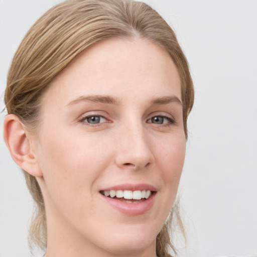 Joyful white young-adult female with medium  brown hair and blue eyes