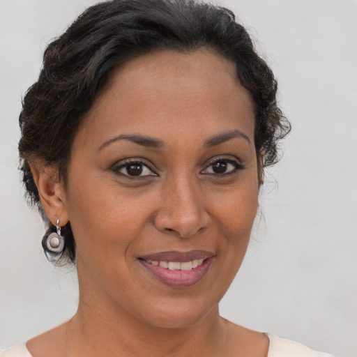 Joyful latino adult female with short  brown hair and brown eyes