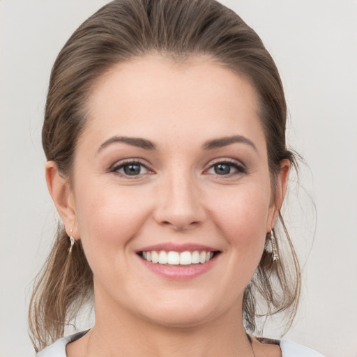 Joyful white young-adult female with medium  brown hair and grey eyes