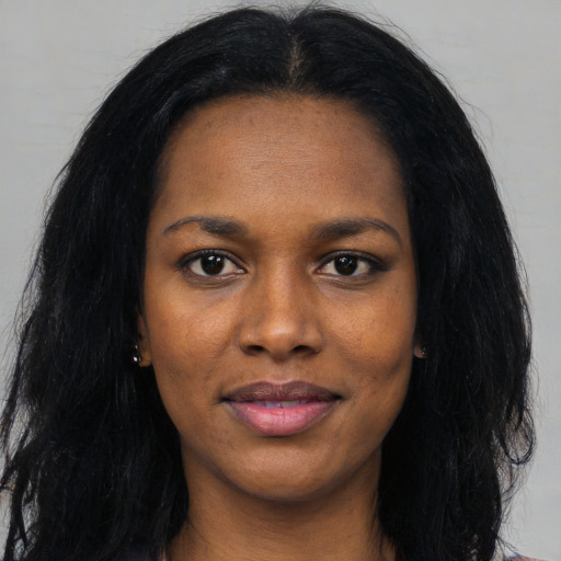 Joyful black young-adult female with long  black hair and brown eyes