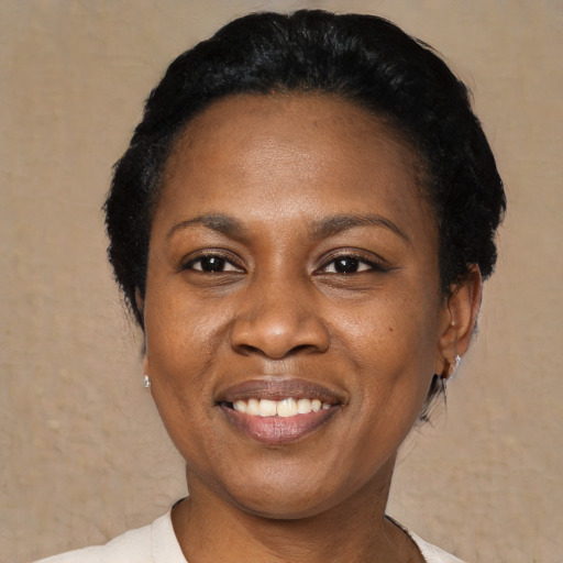 Joyful black young-adult female with short  black hair and brown eyes