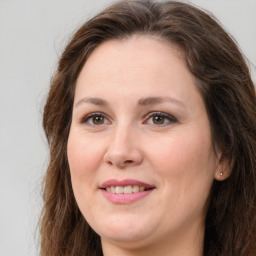 Joyful white adult female with long  brown hair and brown eyes