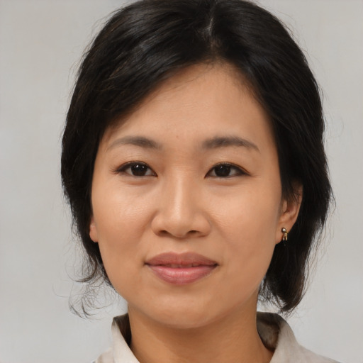 Joyful asian adult female with medium  black hair and brown eyes