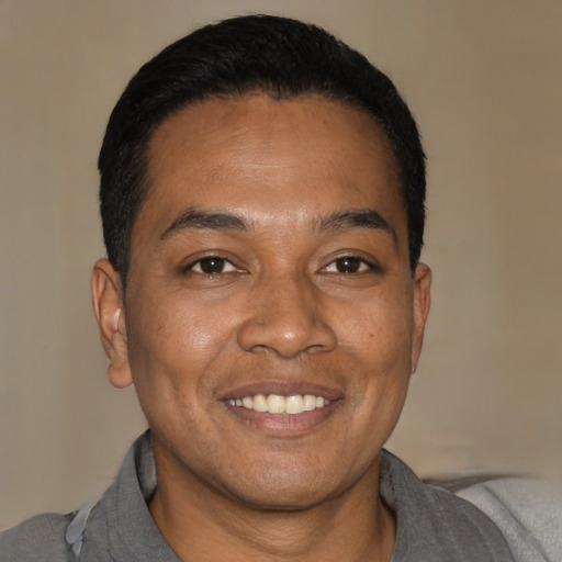 Joyful black young-adult male with short  brown hair and brown eyes
