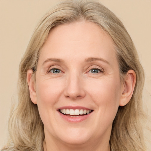 Joyful white adult female with long  brown hair and blue eyes