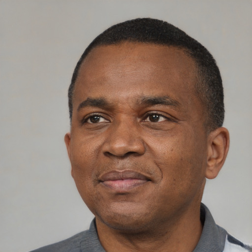 Joyful black adult male with short  black hair and brown eyes