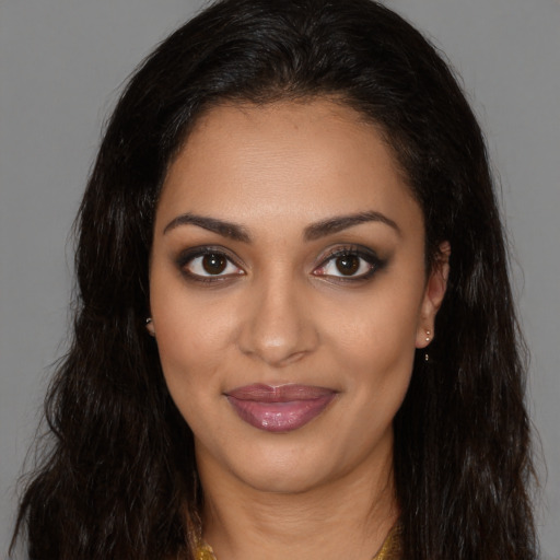 Joyful black young-adult female with long  brown hair and brown eyes