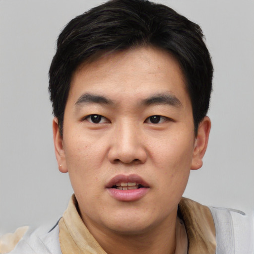 Joyful asian young-adult male with short  black hair and brown eyes