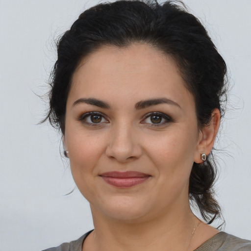 Joyful latino young-adult female with medium  brown hair and brown eyes