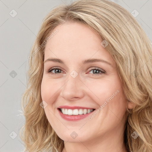 Joyful white young-adult female with long  brown hair and blue eyes