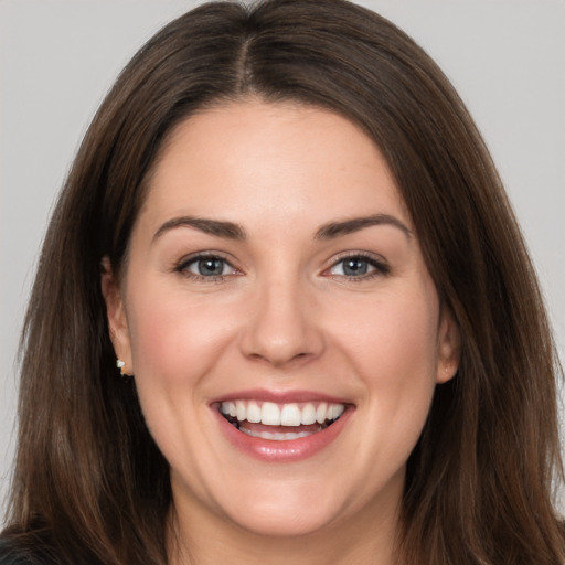 Joyful white young-adult female with long  brown hair and brown eyes