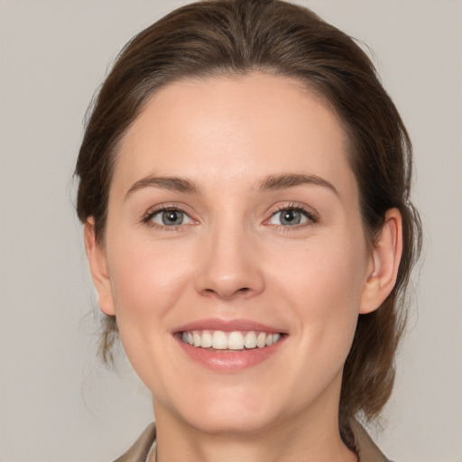 Joyful white young-adult female with medium  brown hair and grey eyes