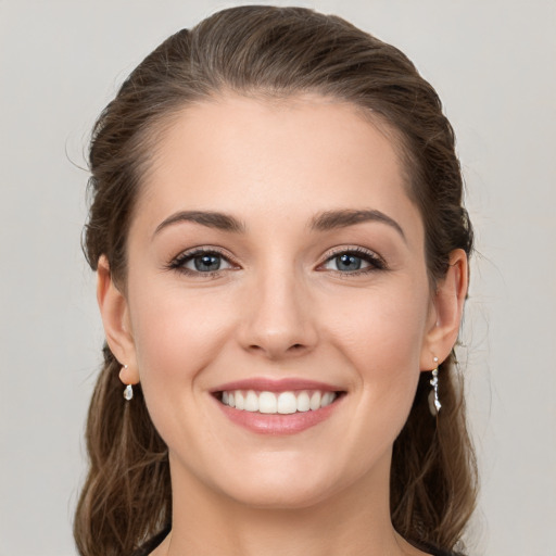 Joyful white young-adult female with long  brown hair and grey eyes