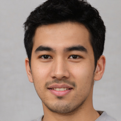 Joyful asian young-adult male with short  black hair and brown eyes