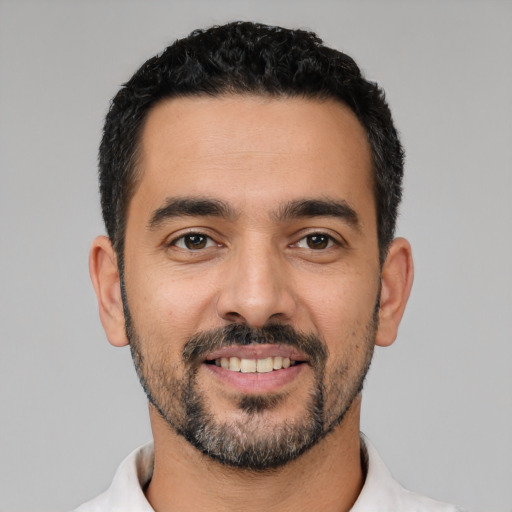 Joyful latino young-adult male with short  black hair and brown eyes