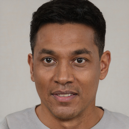 Joyful latino young-adult male with short  black hair and brown eyes