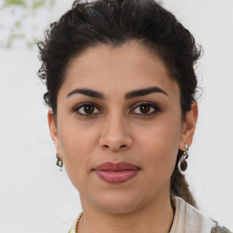 Joyful latino young-adult female with short  brown hair and brown eyes