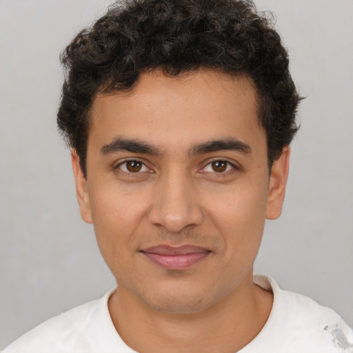 Joyful latino young-adult male with short  brown hair and brown eyes
