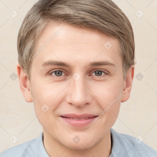 Joyful white young-adult male with short  brown hair and grey eyes