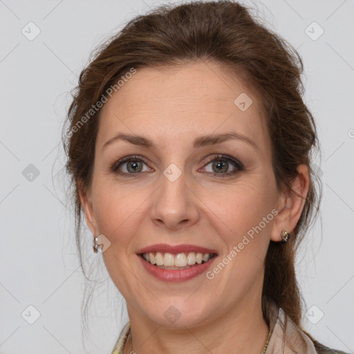 Joyful white adult female with medium  brown hair and grey eyes