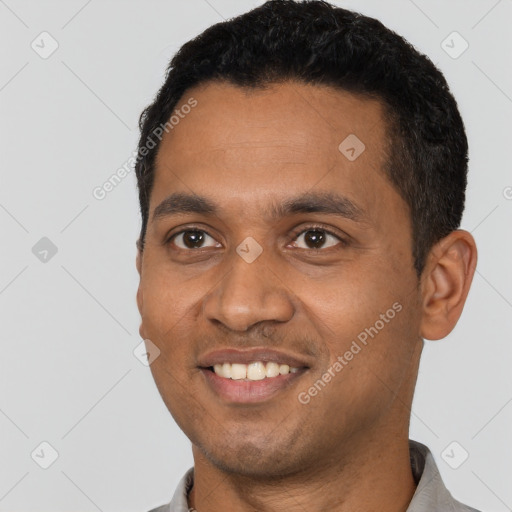 Joyful black young-adult male with short  black hair and brown eyes