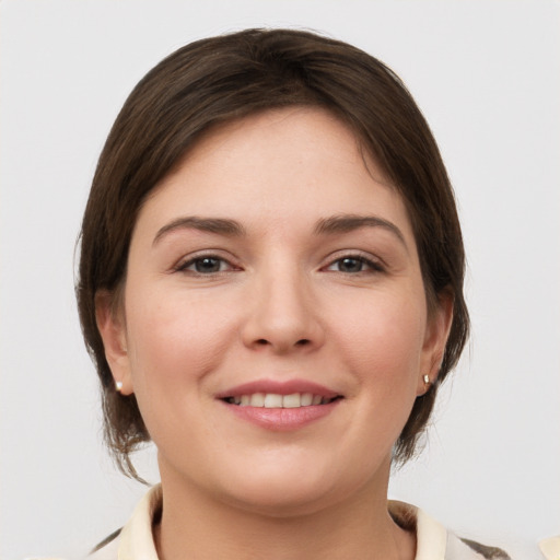 Joyful white young-adult female with medium  brown hair and grey eyes