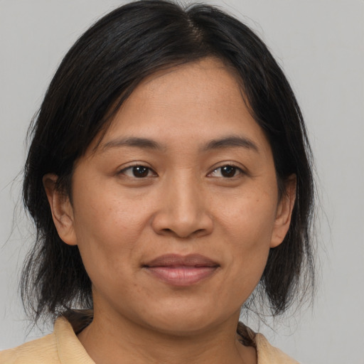 Joyful asian adult female with medium  brown hair and brown eyes