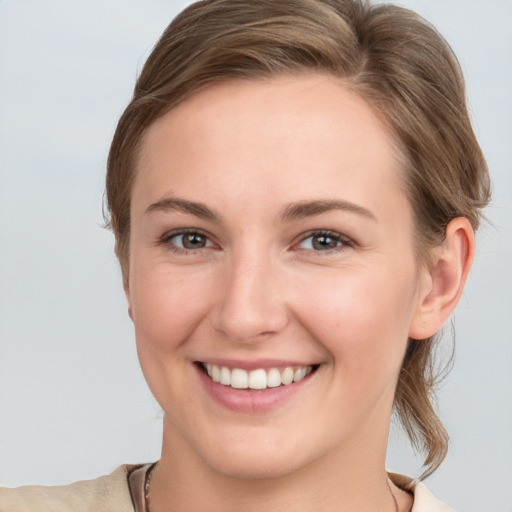 Joyful white young-adult female with medium  brown hair and grey eyes