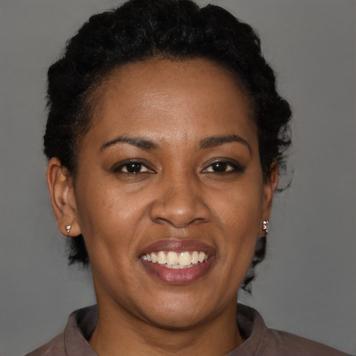 Joyful black adult female with short  brown hair and brown eyes