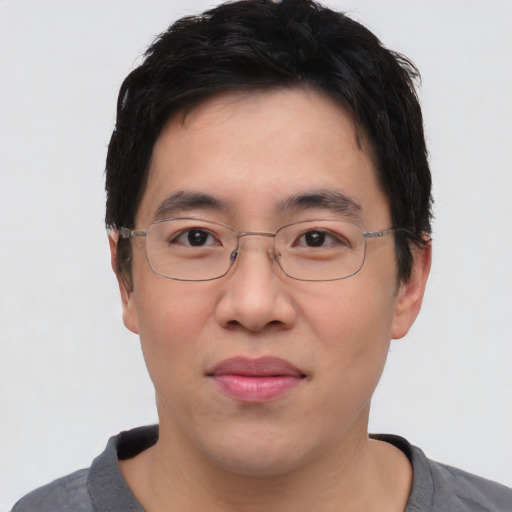 Joyful asian young-adult male with short  black hair and brown eyes