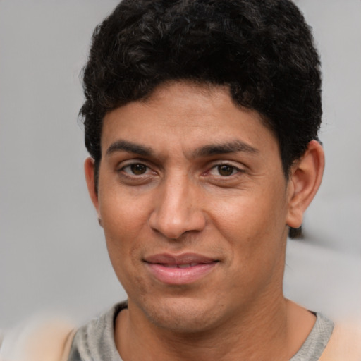 Joyful latino young-adult male with short  brown hair and brown eyes