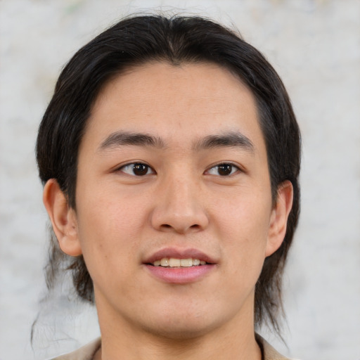 Joyful asian young-adult male with medium  brown hair and brown eyes