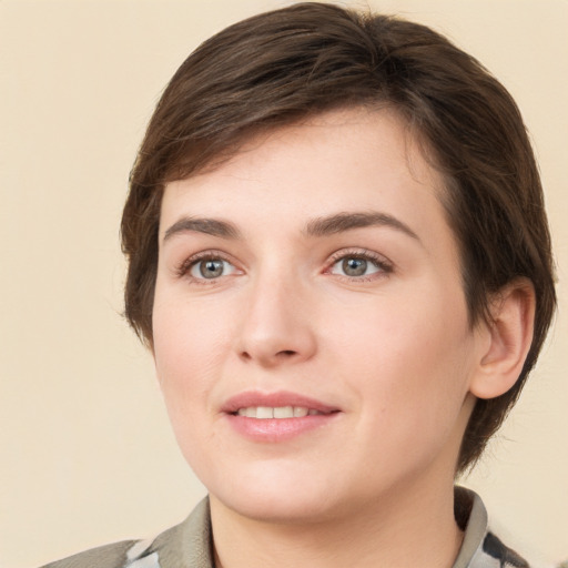 Joyful white young-adult female with short  brown hair and grey eyes