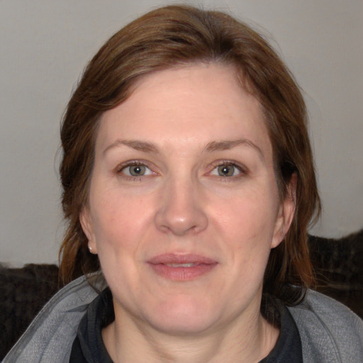 Joyful white adult female with medium  brown hair and blue eyes