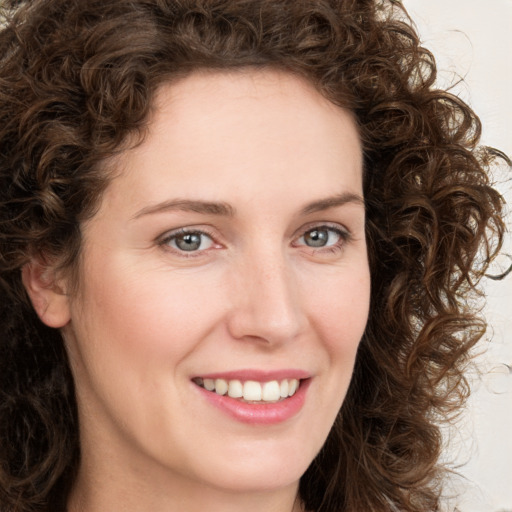 Joyful white young-adult female with long  brown hair and green eyes