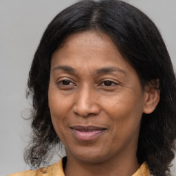 Joyful latino adult female with medium  brown hair and brown eyes