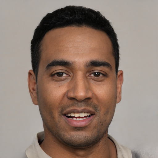 Joyful black young-adult male with short  black hair and brown eyes