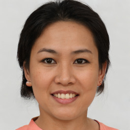 Joyful asian young-adult female with medium  brown hair and brown eyes