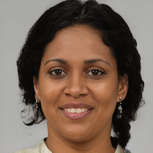 Joyful black adult female with medium  brown hair and brown eyes